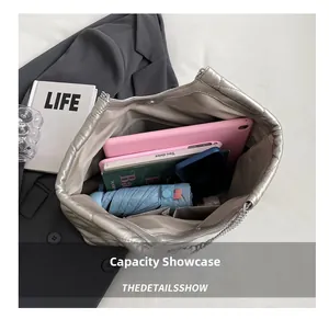 Top view of spacious silver quilted tote bag interior with books and an umbrella
