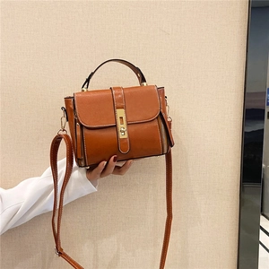 Borsa a tracolla marrone in pelle con manico e chiusura a girello dorata, vista laterale