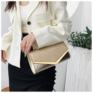 Detail of gold sequin evening clutch with metallic V-trim and delicate chain strap