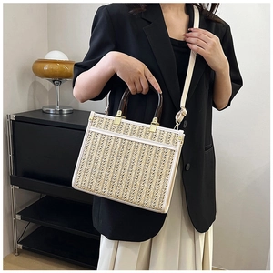 Detail view of the straw tote bag showing woven texture and bamboo handles