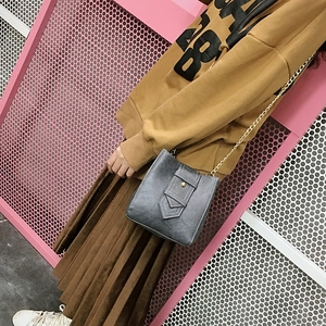 Chic grey bucket crossbody bag with gold chain strap and stylish layered flap design