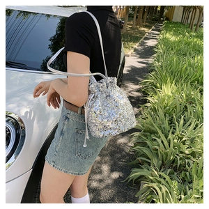 Sac seau chic à paillettes argentées avec cordon de serrage porté à l'épaule en extérieur