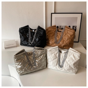 Detailed display of four colors of quilted tote bags with silver chain shoulder straps