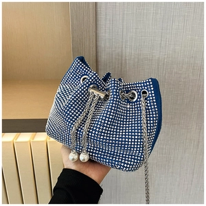 Détail du sac seau en velours bleu avec strass scintillants et breloques en perles