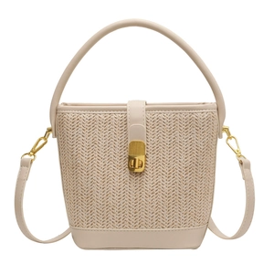 Beige woven straw bucket bag with leather straps and gold twist lock for vacation