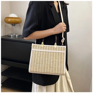 Detail of woven straw tote bag with white leather trim and round wooden handles