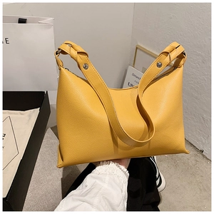 Dettaglio borsa tote giallo senape con trama litchi e tracolla con nodo decorativo