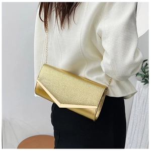 Fashionable gold clutch bag with metallic texture and V-shaped trim worn over the shoulder