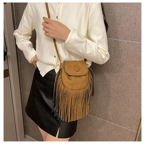 Bohemian brown suede saddle bag with long fringe tassels worn by a model in casual style