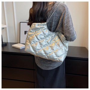 Detail of silver quilted tote bag with diamond stitching and metal chain strap