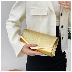Detail of elegant gold evening clutch with woven texture and gold V-shaped metal trim