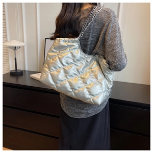Detailed view of silver quilted tote bag with metallic texture and double chain straps
