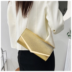 Detail of gold evening clutch bag featuring mesh texture and V-shaped metallic trim