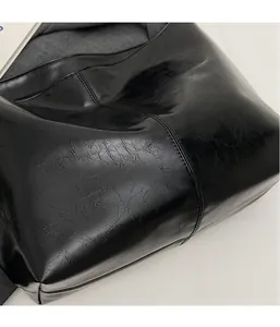 Detailed close-up of black PU leather texture with wrinkled oil-wax finish on tote bag