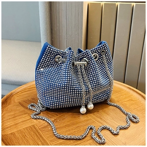 Détail du sac seau bleu en strass avec fermeture à cordon et breloques en perles