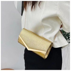 Detail of elegant gold evening clutch with metallic chain and stylish V-shape metal trim