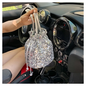 Détail du sac seau à paillettes argentées avec fermeture à cordon et anse en cuir