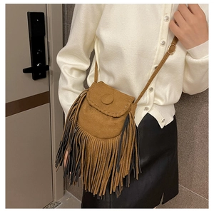 Close-up of brown suede saddle bag featuring long fringe tassels and retro buckle details