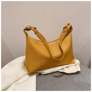 Dettaglio borsa tote gialla in pelle martellata con tracolla intrecciata e rivetti