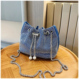 Détail du sac seau bleu en strass avec perles de serrage et bandoulière chaîne argent
