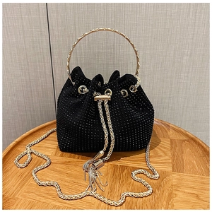 Détail du sac seau en strass noir avec poignée en métal et bandoulière en chaîne dorée