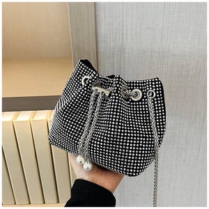 Détail du sac seau en strass avec chaîne argentée et cordon de serrage perle élégant
