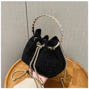 Détail du sac seau en strass noirs avec poignée ronde dorée et ornements en cristaux
