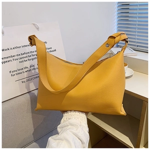 Dettaglio della borsa tote in pelle gialla con tracolla annodata e chiusura a zip