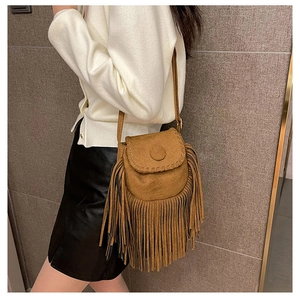Detail of vintage suede tassel saddle bag with fringe accents and rustic stitching