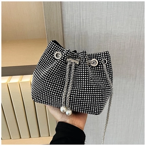 Vue détaillée du sac seau noir en strass avec œillets métalliques et breloque perle