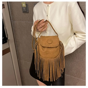 Detail of brown suede saddle bag with long fringe tassels and a bohemian finish