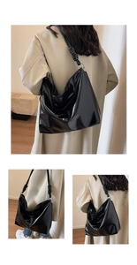 Detail view of glossy black hobo tote with quilted stitching and metallic ring decor