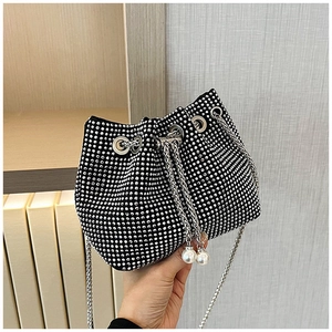 Détail du sac seau en strass avec fermeture à cordon et accents de perles blanches