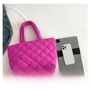 Detail of rose red quilted tote bag shown next to a tablet for size comparison