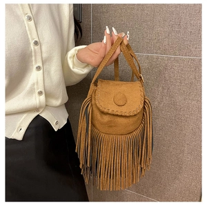 Detail of vintage brown suede crossbody bag with long fringes and braided stitching