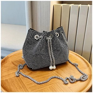 Détail du sac seau en strass avec bandoulière chaîne argentée et cordon à perles blanches