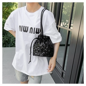 Détail du sac seau à paillettes noires avec fermeture à cordon et finition texturée