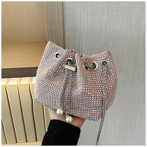 Détail du sac seau rose clair avec strass, cordon à perles et bandoulière en chaîne argentée