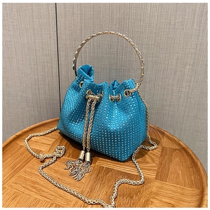 Détail du sac seau bleu lac avec strass, poignée dorée et glands métalliques chic