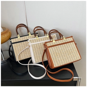 Detail of woven straw tote bags in black white and brown with acrylic ring handles