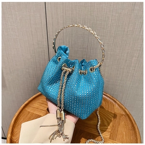 Détail du sac seau en strass bleu sarcelle avec poignée métallique et pompon chaîne