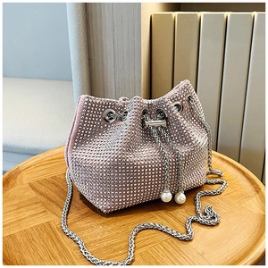 Gros plan détaillé du sac seau en strass rose avec chaîne argentée et cordon en perles