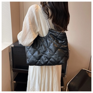 Classic black quilted shoulder bag with silver chain strap shown in a real-life setting