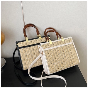 Close-up of handwoven tote bag with amber acrylic handle and metallic hardware