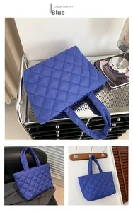 Detail view of the blue quilted tote bag fabric with geometric diamond stitching