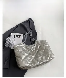 Detail view of silver quilted tote bag with metallic texture and chain shoulder strap