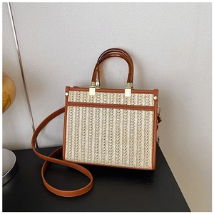 Detail of vintage woven tote bag with brown leather trim and acrylic handles