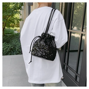 Détail du sac seau à paillettes noires avec cordon de serrage porté par un mannequin
