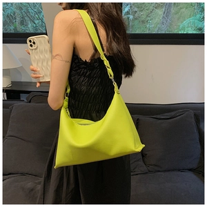 Dettaglio della borsa hobo verde lime con tracolla intrecciata e pelle con grana litchi