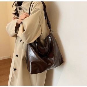 Detail of soft leather shoulder bag with knot decoration and metallic ring hardware